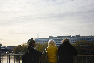 Rear view of friends standing at river