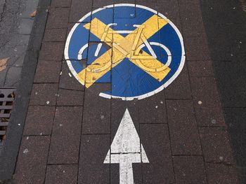 High angle view of arrow symbol with bicycle lane on footpath