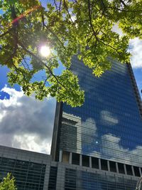 Low angle view of skyscrapers against cloudy sky