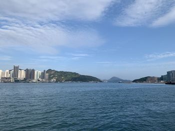 Scenic view of sea by buildings against sky