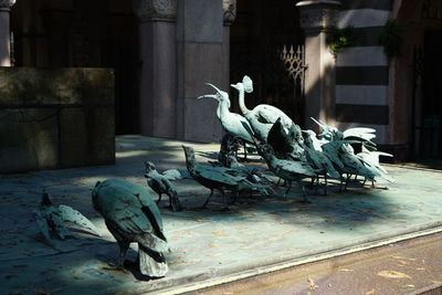 Statue of birds by historic building