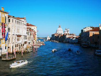 Boats in canal amidst buildings in city