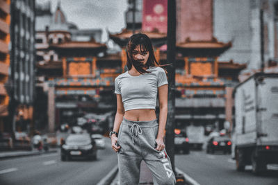 Portrait of young woman standing in city