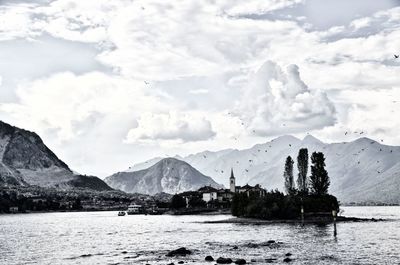 Scenic view of lake by mountains against sky