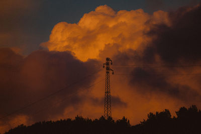 Low angle view of silhouette electricity pylon against sky during sunset