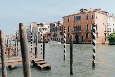 Wooden posts in canal against clear sky