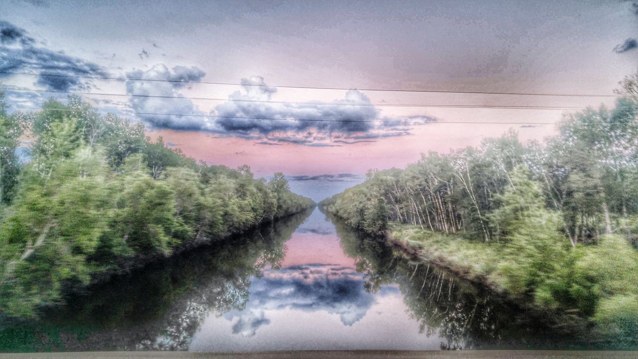 water, reflection, tree, sky, tranquil scene, lake, tranquility, scenics, beauty in nature, nature, cloud - sky, standing water, plant, cloud, idyllic, no people, outdoors, growth, day, non-urban scene, green color, landscape, calm, cloudy, canal, remote, grass, non urban scene, diminishing perspective, weather, green