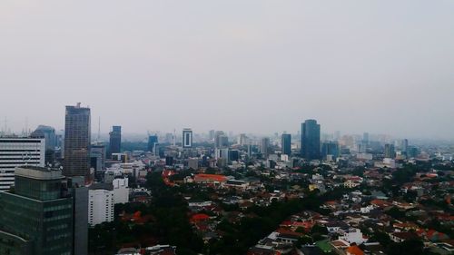 Aerial view of buildings in city against clear sky