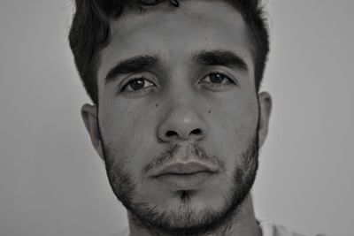 Close-up portrait of young man against gray background