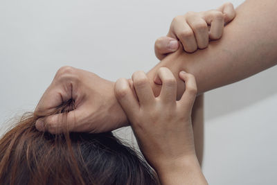 Close-up of hands over white background