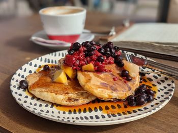 Close-up of pancakes for breakfast served on wooden table