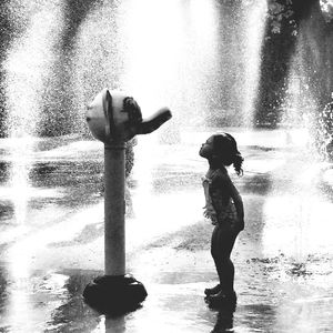Full length of boy standing on fountain