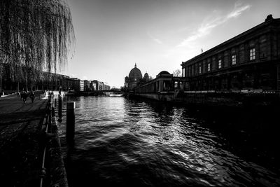 Boats in river against buildings in city