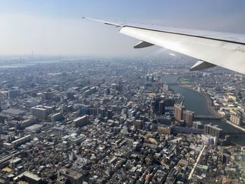 Aerial view of city and airplane against sky