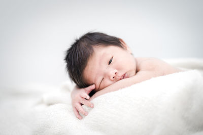 Portrait of cute baby lying on bed