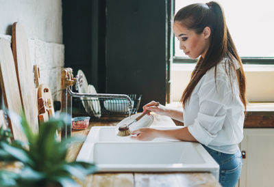 Smiling young woman standing at home