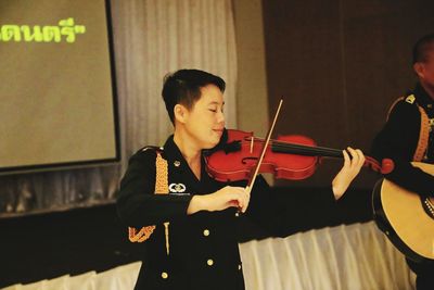 Young man playing guitar at music concert