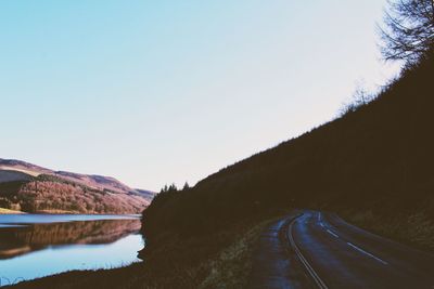 Road by mountain against clear sky