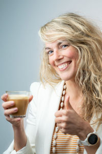 Portrait of a smiling young woman drinking glass