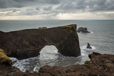 Scenic view of rocks in sea against sky