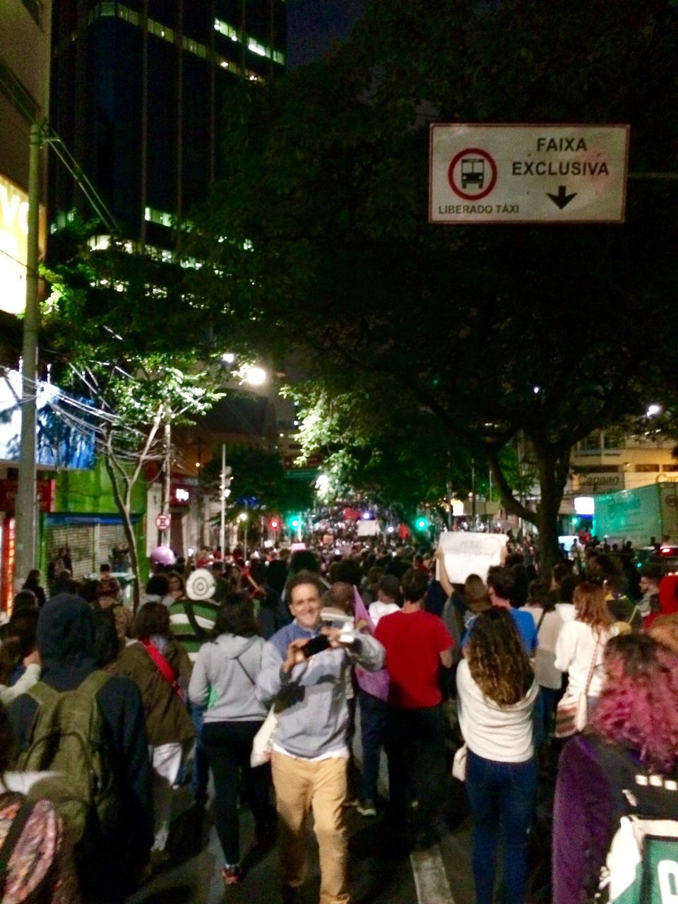 PEOPLE WALKING IN FRONT OF ILLUMINATED BUILDING