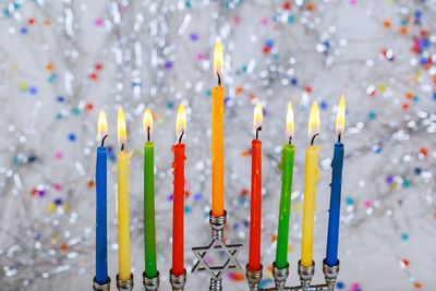Close-up of colorful candles burning against decorations