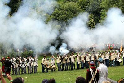 Group of people shooting guns on land