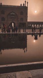 Group of people in front of building at sunset