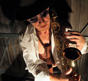 High angle view of mature musician with saxophone