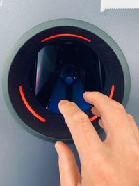 Midsection of person photographing mirror