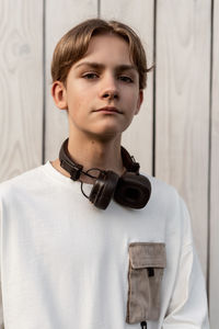 Portrait of young man standing against wall