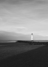 Lighthouse by sea against sky