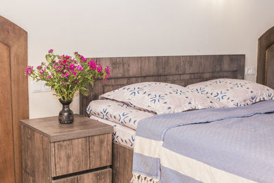 Flower vase on table against wall at home