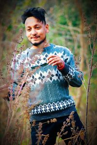 Smiling young man standing on land