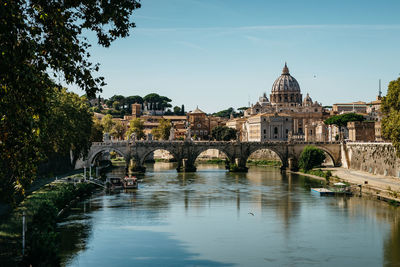 Arch bridge over river against buildings