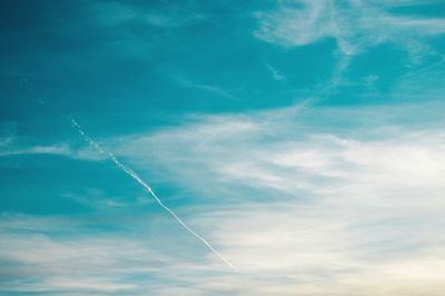 Low angle view of vapor trail against blue sky