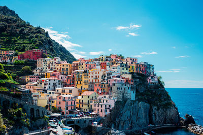 Buildings by sea against sky