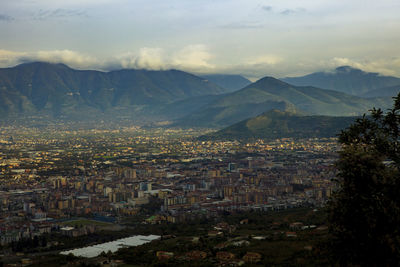 High angle view of townscape by mountains against sky