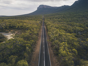 Scenic view of road by mountain against sky