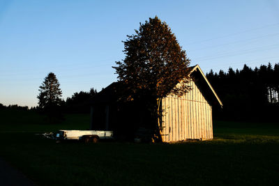 House on field against clear sky