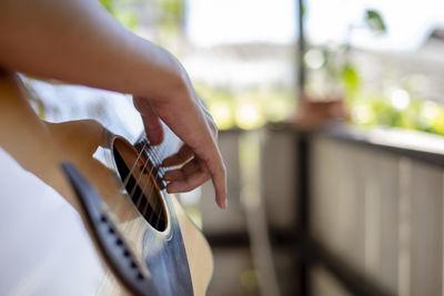 Midsection of person playing guitar