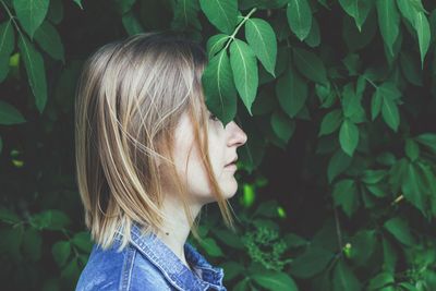 Side view of woman against tree