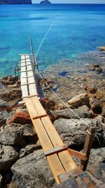 Narrow footbridge at calm blue sea