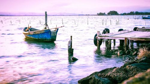 Boats moored in sea against sky