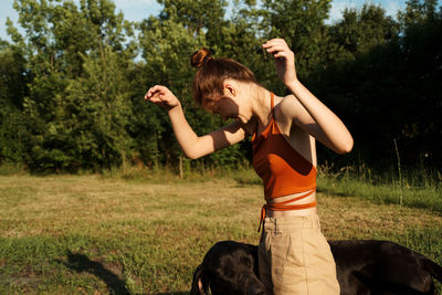 Full length of woman with dog against trees