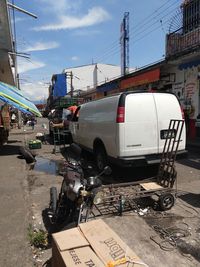 Vehicles on road in city against sky