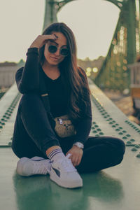 Young woman sitting on the bridge