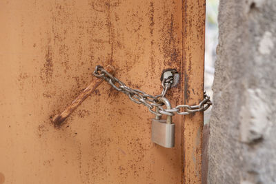 Close-up of padlock on chain against wall