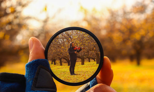 Midsection of woman holding umbrella during autumn