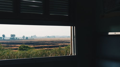 Scenic view of field seen through train window